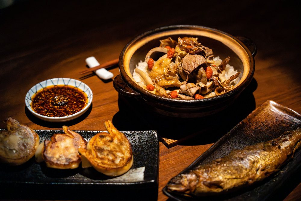 英雄塚餐點：麻油雞炊飯、日式煎餃、香魚甘露煮 ©陳育陞/旅讀